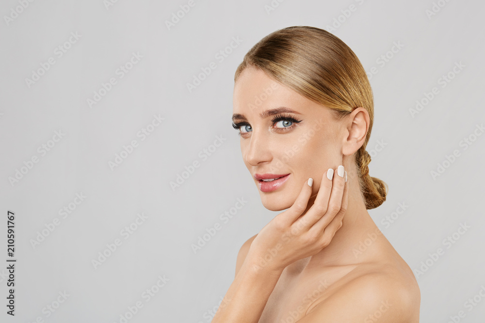 Portrait of smiling beautiful blonde woman with natural make up touching her face. Beauty young woman with fresh clean perfect skin. Skin care concept. Cosmetology,beauty and spa. Facial treatment. Portrait of smiling beautiful blonde woman with natural make up touching her face. Beauty young woman with fresh clean perfect skin. Skin care concept. Cosmetology,beauty and spa. Facial treatment.