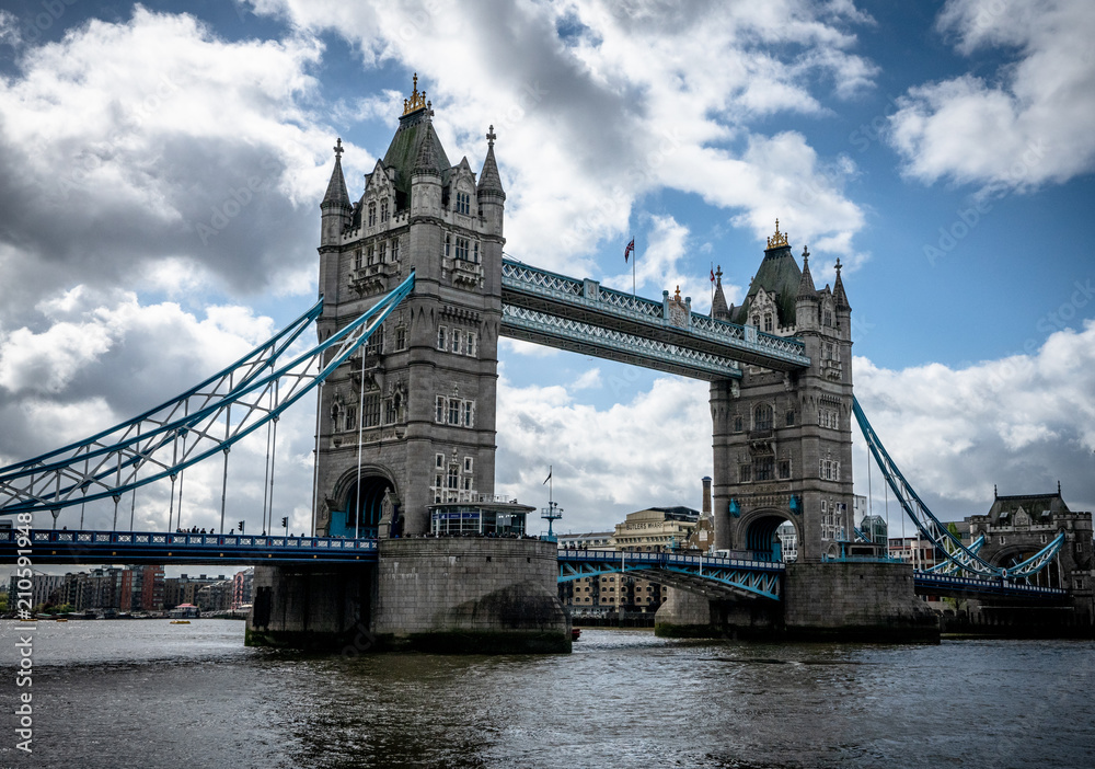 Obraz premium Tower Bridge w Londynie z dramatycznym zachmurzeniem i błękitnym niebem