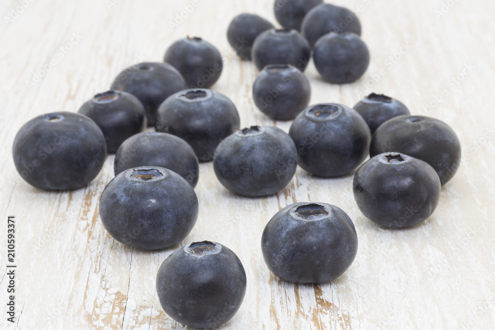 Blueberries in the foreground on white wooden background Blueberries in the foreground on white wooden background