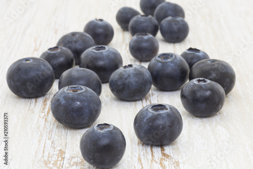 Blueberries in the foreground on white wooden background