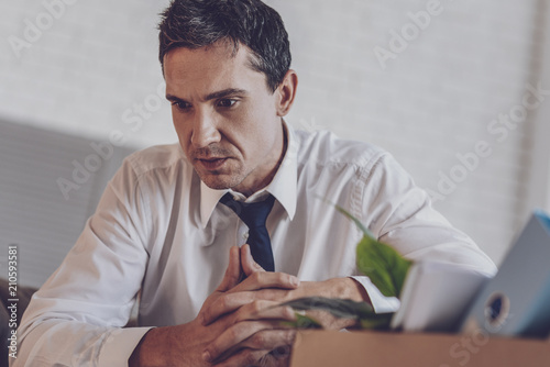 Sad mood. Nice young man feeling upset while being fired from work