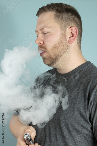Young man vaping smoking an e-cigarette