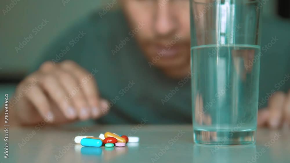 man taking pills at home is ill sick slow motion video. Healthcare and medical concept disease lifestyle. male takes a pill and drinks a glass of water indoors man taking pills at home is ill sick slow motion video. Healthcare and medical concept disease lifestyle. male takes a pill and drinks a glass of water indoors