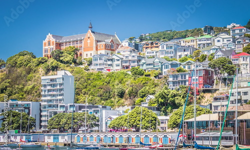 Foto Oriental Parade boat sheds nestled below the iconic St Gerard's Monastery, one of the city's most recognized landmarks on Mount Victoria