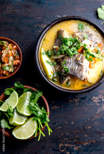 CHILEAN FOOD. Fish soup CALDILLO DE CONGRIO served in clay bowl, top view photo