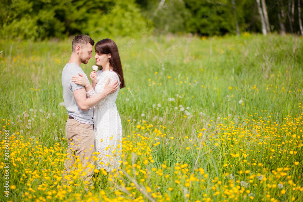 Couple standing and embracing in the yellow meadow Couple standing and embracing in the yellow meadow