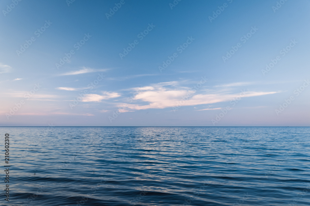 Obraz premium Clouds over blue sea waves. Sky reflecting in water. Ladoga lake.