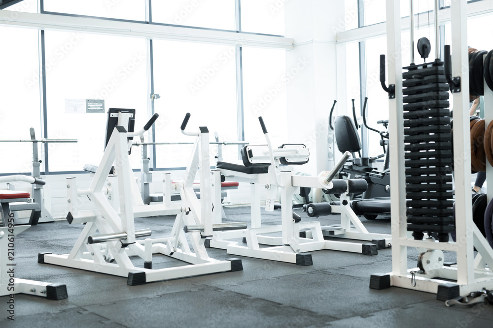 Background image of modern gym interior with big windows and exercise machines, copy space