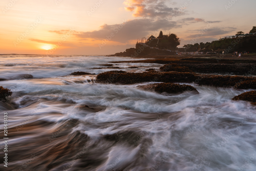 Seascape in sunset with strong wave at Tanah Lot Temple in Bali, Indonesia. Famous landmark tourist attraction and travel destination 