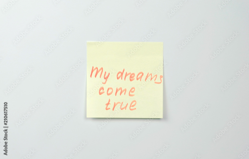 Note on yellow sticker paper sheets with motivation words my dreams come true. Note on yellow sticker paper sheets with motivation words my dreams come true.
