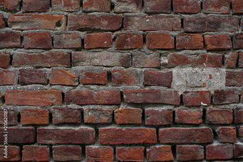 Background: a wall of old red brick with elements of cement mortar.