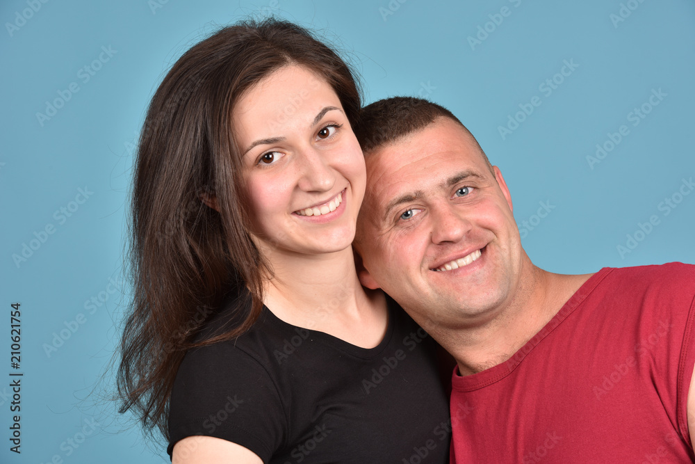 Young family on a blue background. Perfect pair. A good relationship. Strong friendship. Young family on a blue background. Perfect pair. A good relationship. Strong friendship.