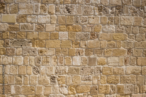 Sandstone, limestone aged wall at Cyprus. Yellow stonewall background, close up view with details.