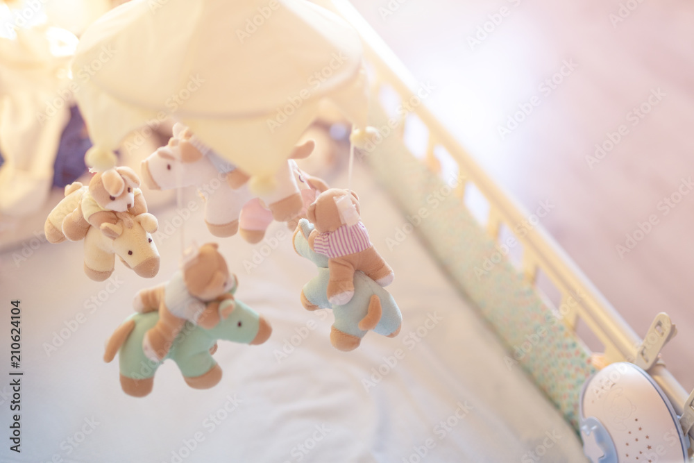 Close-up baby crib with musical animal mobile at nursery room. Hanged developing toy with plush fluffy animals. Happy parenting and childhood, expectation delivery of a child concept - obrazy, fototapety, plakaty 