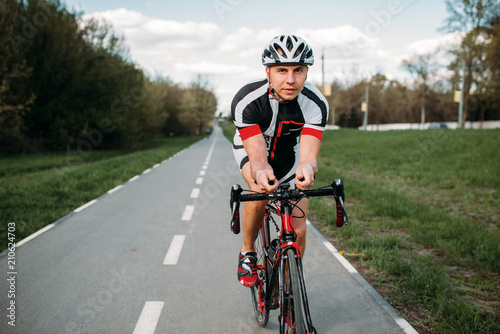 Male cyclist rides on bicycle, front view