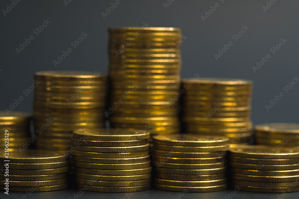 Savings, increasing columns of coins, piles of coins arranged as a graph in dark room, business banking concept. Savings, increasing columns of coins, piles of coins arranged as a graph in dark room, business banking concept.