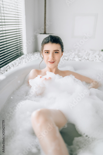 Sexy woman lying in bath with foam