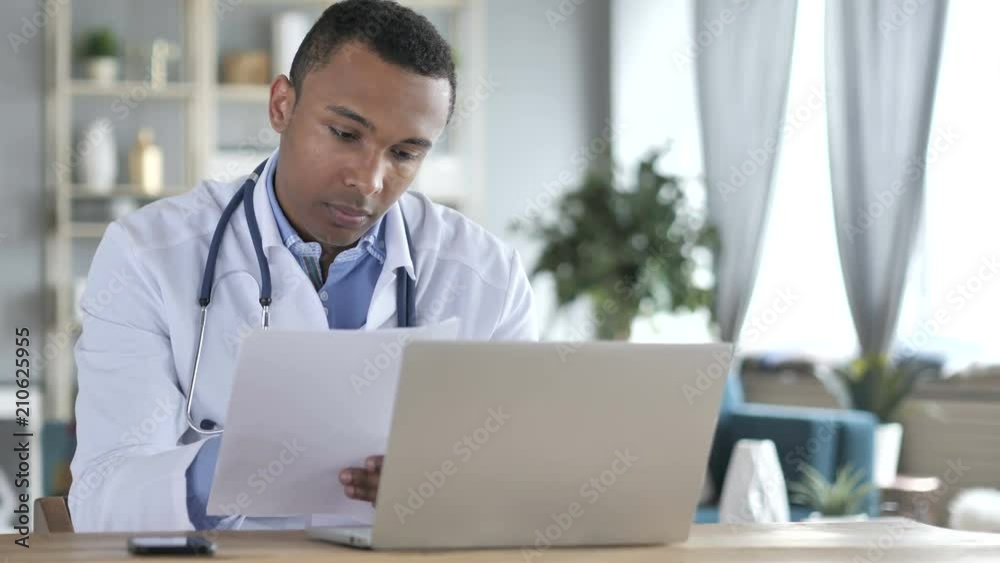 African-American Doctor Reading medical Report, Diagnosing Patient