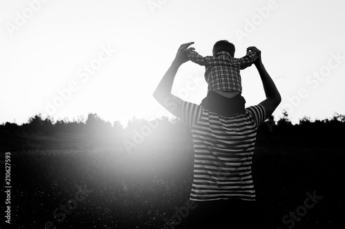 Father and son playing in the park at the sunset time. Happy family having fun outdoor