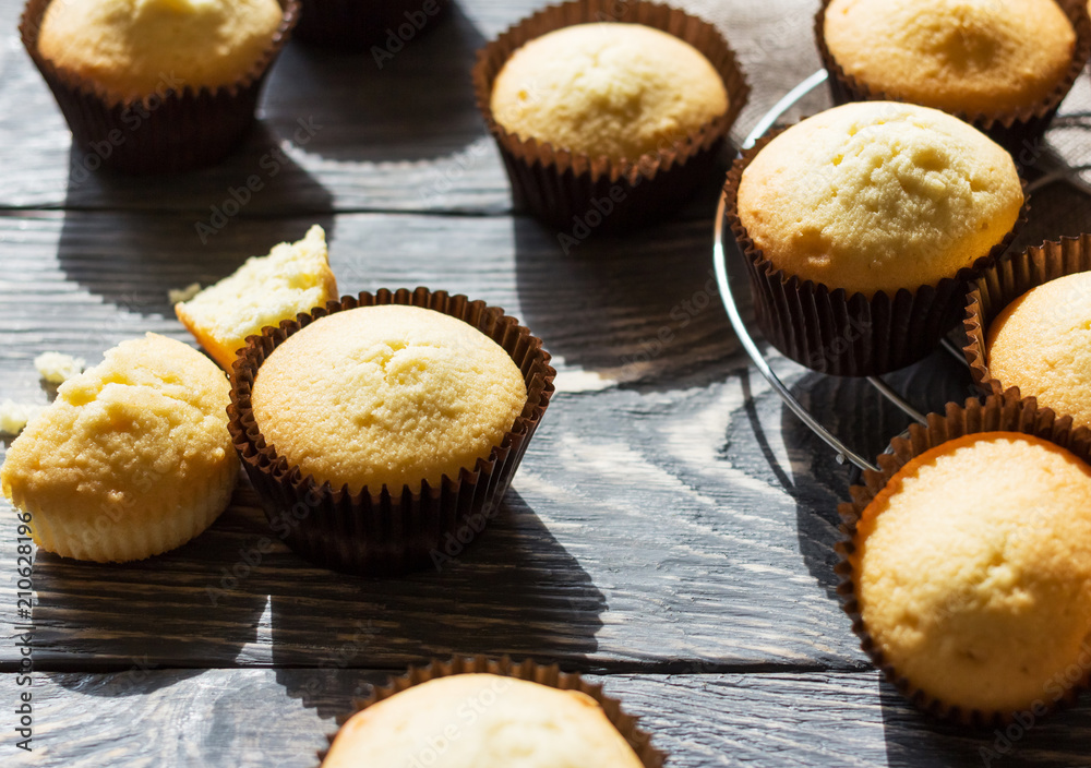 Fragrant vanilla cupcakes in molds on wooden surface Fragrant vanilla cupcakes in molds on wooden surface