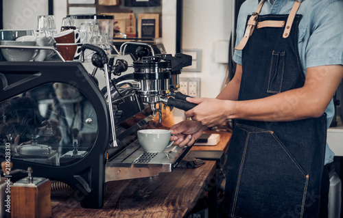 Close up male barista making hot coffee with machine at counter bar in cafe restaurant Food and drink service concept.