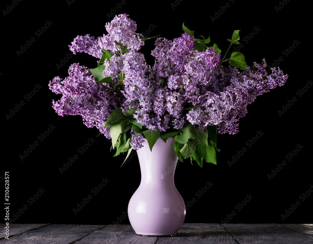 Lush bouquet of blooming lilac in vase isolated on black Lush bouquet of blooming lilac in vase isolated on black