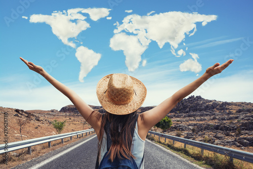 Happy travel woman on vacation concept with world shaped clouds. Funny traveler enjoy her trip and ready to adventure.