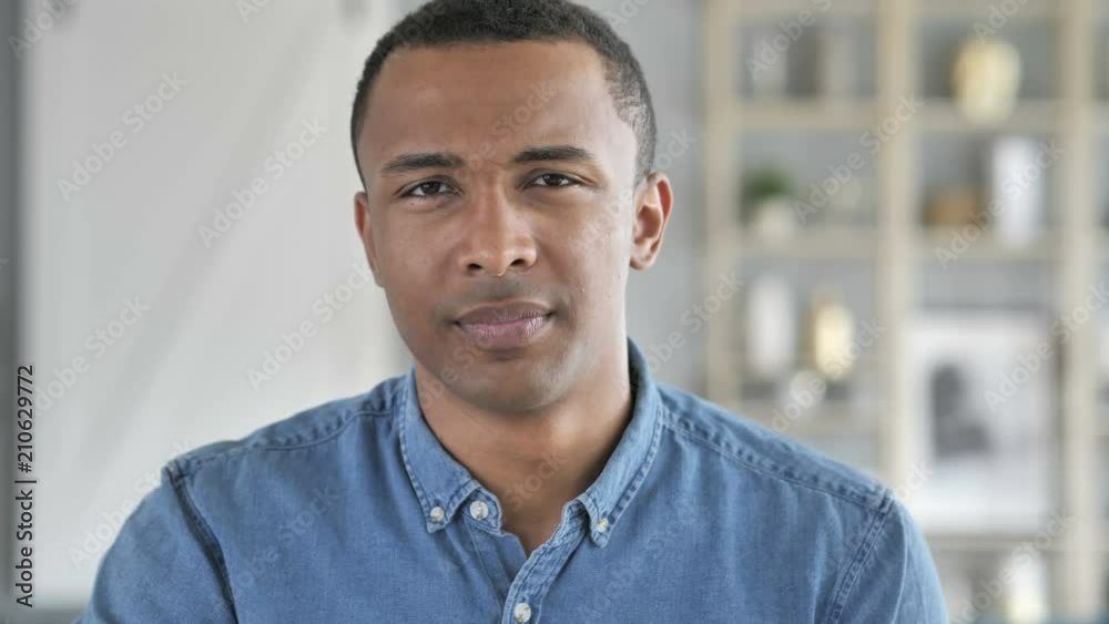 No, Young African Man Rejecting Offer by Waving Finger No, Young African Man Rejecting Offer by Waving Finger
