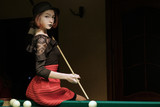 beautiful girl in a hat in the billiard room