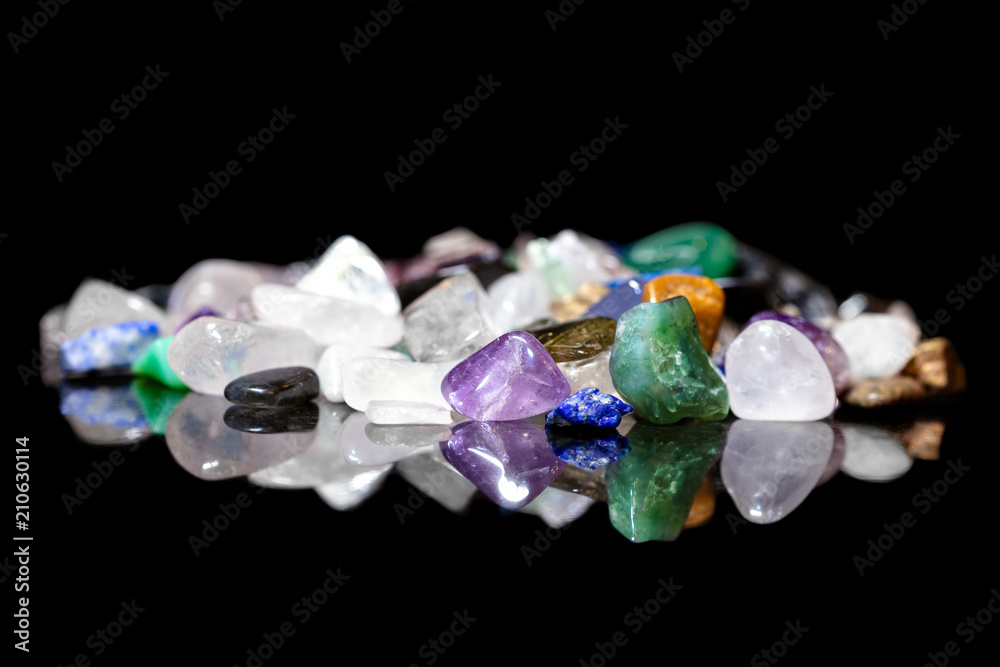 Verschiedene Mineralien und Edelsteine getrommelt und roh vor Schwarz Stock  Photo | Adobe Stock