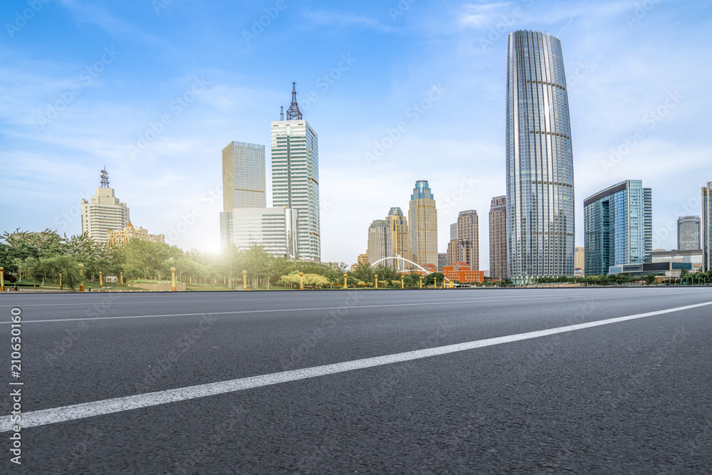 The empty asphalt road is built along modern commercial buildings in China's cities. The empty asphalt road is built along modern commercial buildings in China's cities.