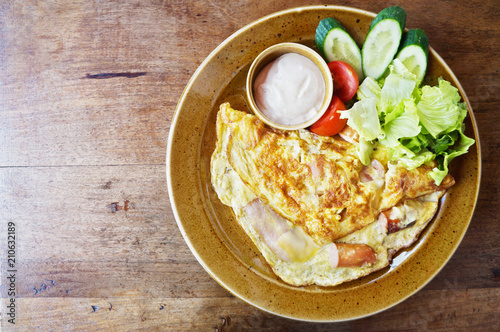 Omelette or scrambled eggs with bacon, cheese and fresh vegetables, top view with space for text 