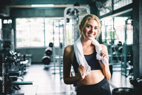 Woman relaxing after finishing workout and weight training at sport gym