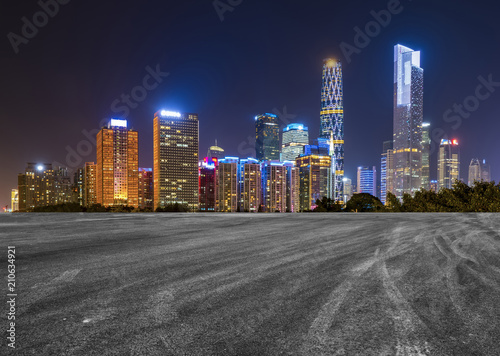 The empty asphalt road is built along modern commercial buildings in China s cities.