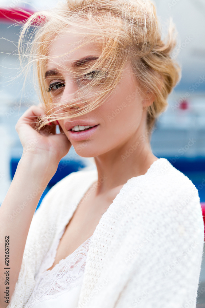 Close-up portrait of beautiful caucasian blond woman walking outdoors. Beautiful woman in white shirt. Fashion portrait of gorgeous woman. Young woman having fun in city. Street fashion.