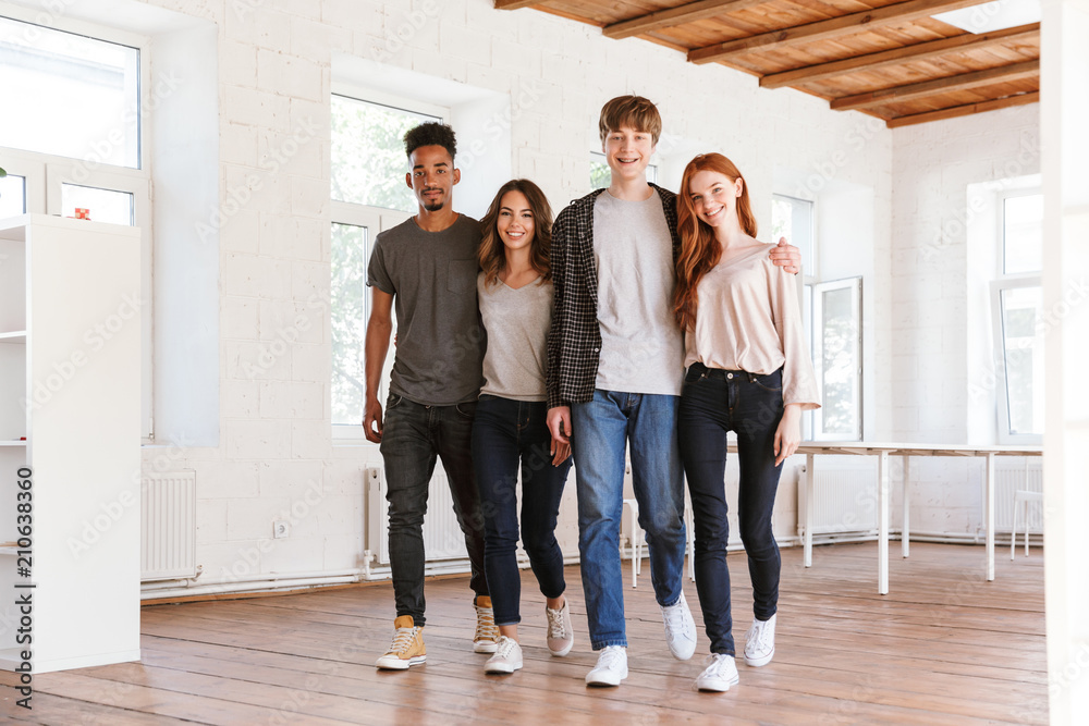 Fototapeta premium Cheerful friends students walking in classroom