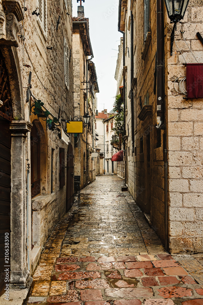 Narrow european street with old historical buildings in the ancient town Kotor in Montenegro