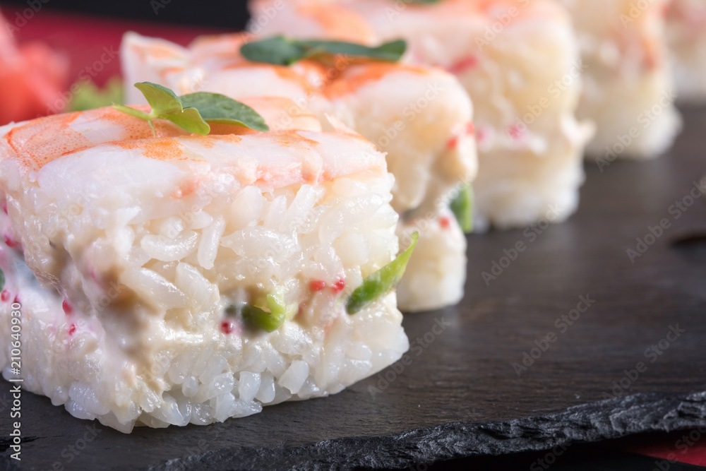 Японская кухня. Горячие и холодные закуски из морепродуктов. Суши и роллы и креветки. Японская еда и морепродукты в ресторане.