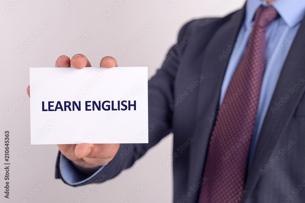 Man showing paper with LEARN ENGLISH text Man showing paper with LEARN ENGLISH text