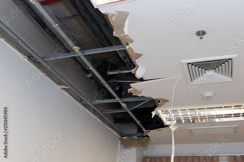 Ceiling panels damaged hole in the roof of house from drain pipes water leakage. House problem from plumber system.