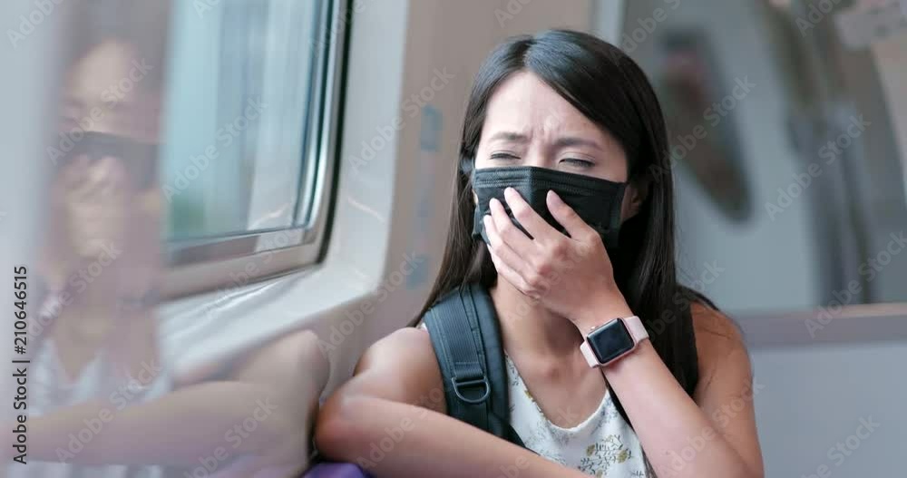 Woman wearing protective mask and taking train