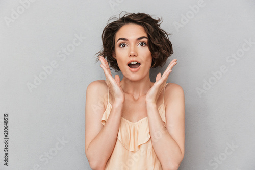Portrait of a surprised woman with hands at her face