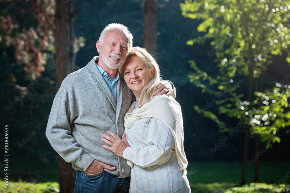 Happy senior couple smiling outdoors in nature Happy senior couple smiling outdoors in nature
