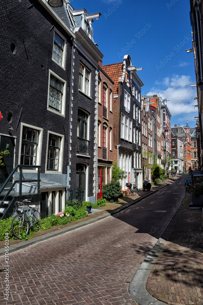 Straße mit typischen Häusern in der Innenstadt von Amsterdam, Niederlande.
