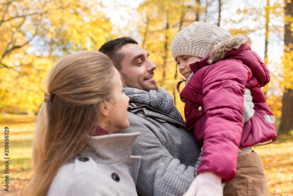Fototapeta premium family, season and people concept - happy mother, father and little daughter at autumn park
