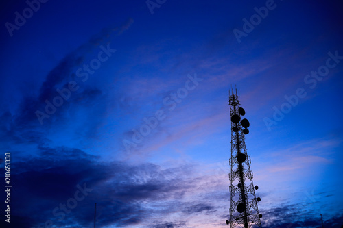 Telecommunication tower Antenna and satellite dish at sunset sky background.