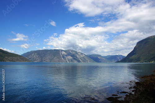 Landscape on the fjord in Norway from the seashore  the mountain on the other side  blue clear water