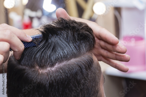 men's hair Styling and grooming with the help of scissors machine and hair clippers in the hair salon.