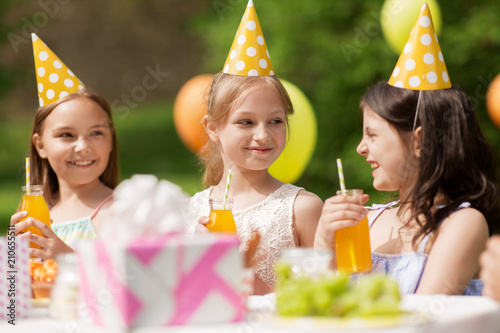 Photography holidays, childhood and celebration concept - happy girls drinking juice on birt