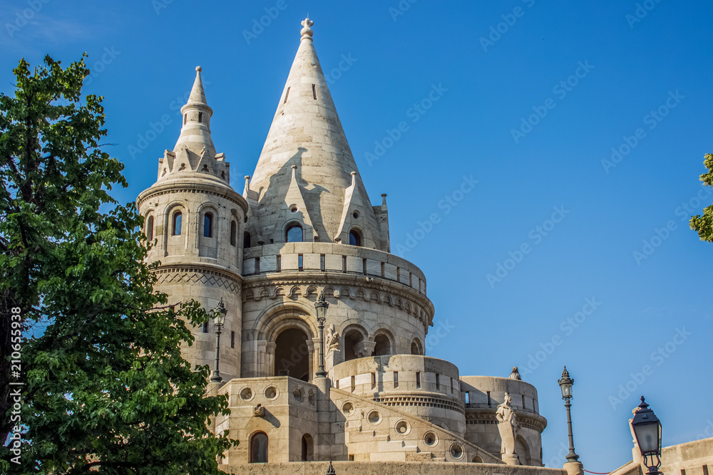 fairy tale white castle palace architecture building with towers on blue sky background between green trees in summer time bright colorful day